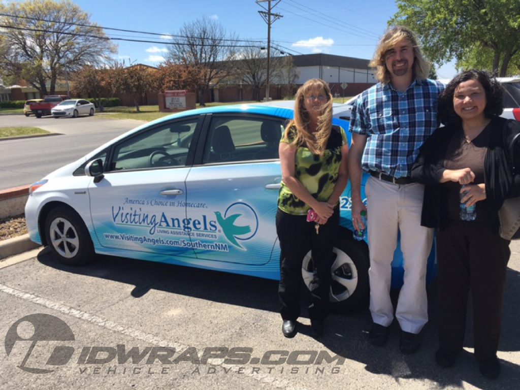 Prius graphic wrap pictured with proud owners and staff.