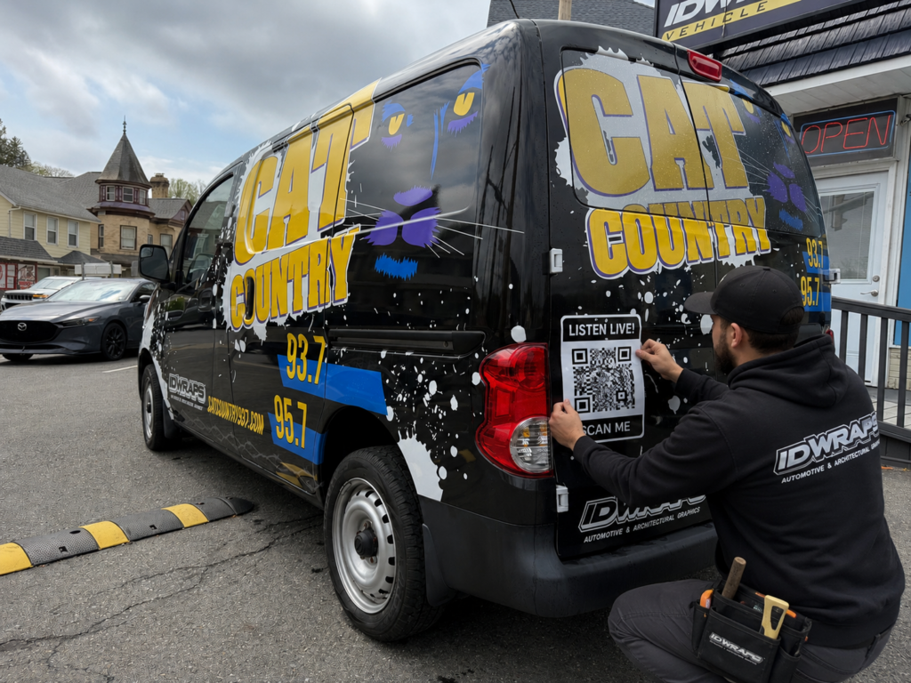 3M graphic installer applying overlay graphics to a full van wrap